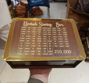 Wooden saving box with gold accents and engraved numbers, held by a person.