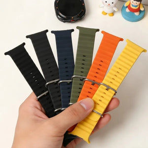 Set of colorful watch straps held by a hand on a white background