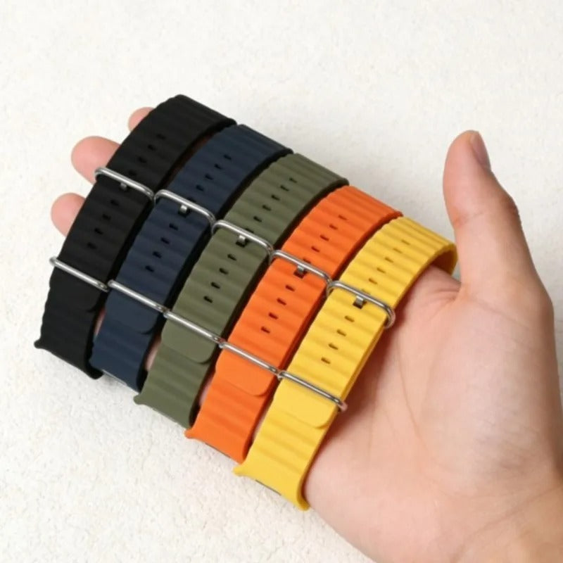Set of five colorful watch straps held in a hand against a white background